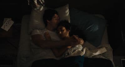 a man and a woman laying on a bed together