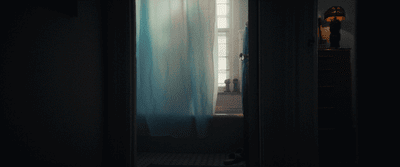 a dark room with a window and a curtain