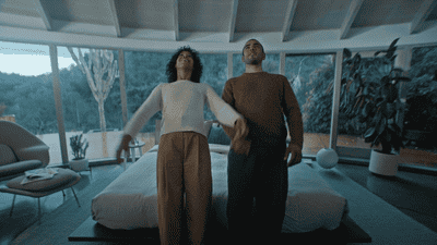 a man and a woman standing in front of a bed