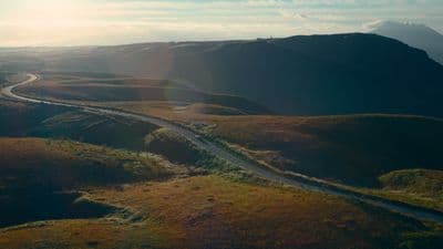 an aerial view of a winding road in the mountains