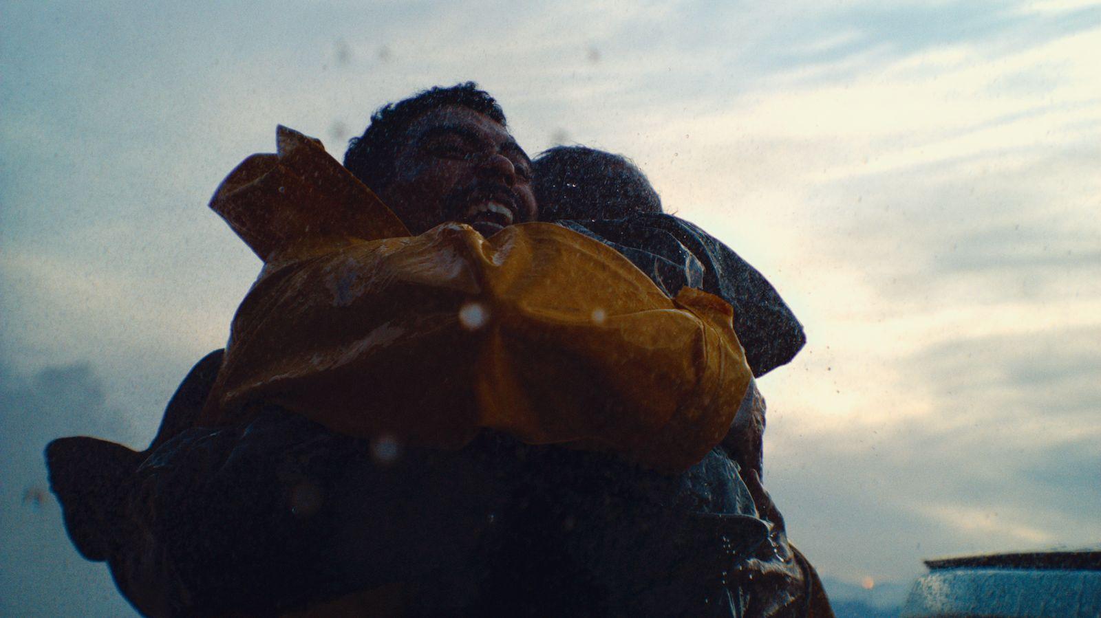 a man and a woman wrapped in a yellow jacket