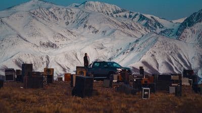 a car parked in a field with a mountain in the background