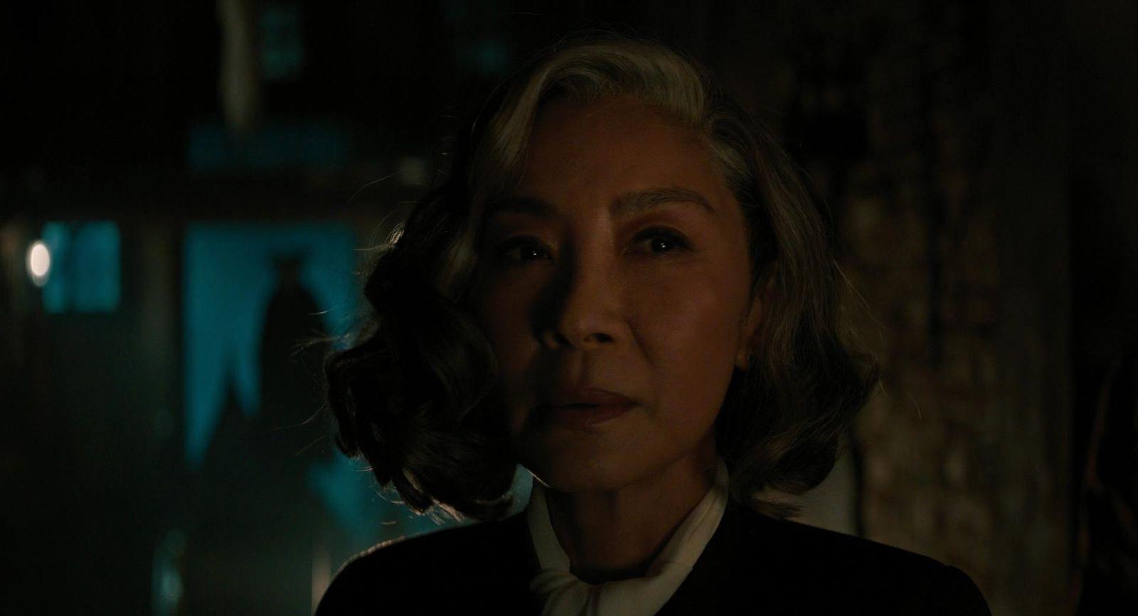 an older woman in a dark room looking at the camera