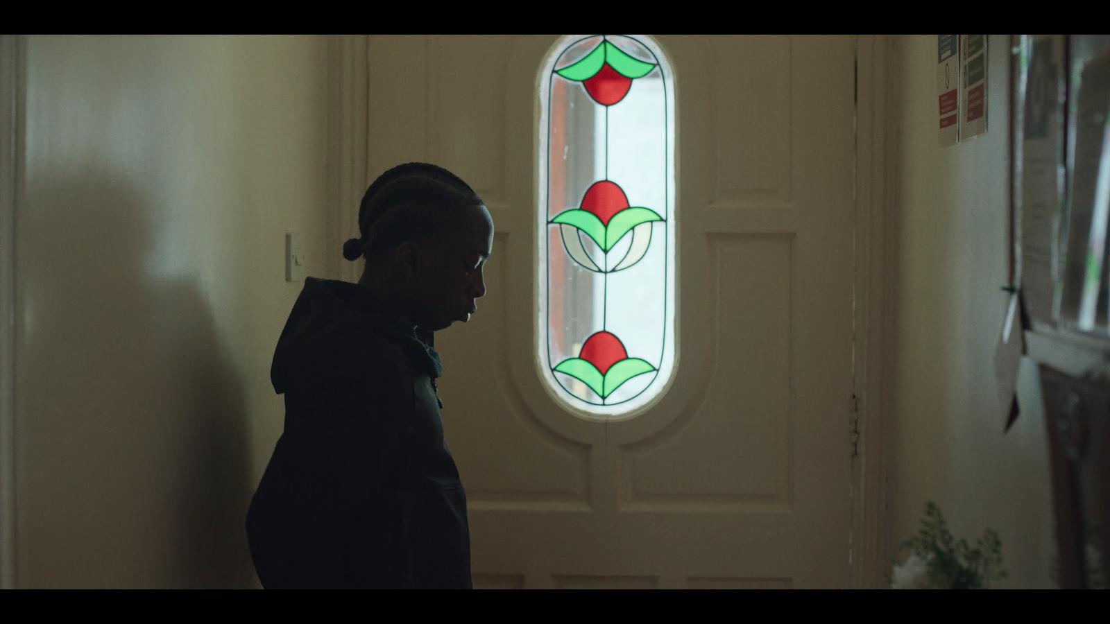 a person standing in front of a door with a stained glass window