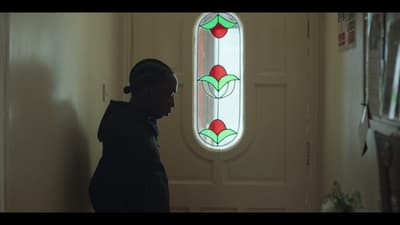a person standing in front of a door with a stained glass window