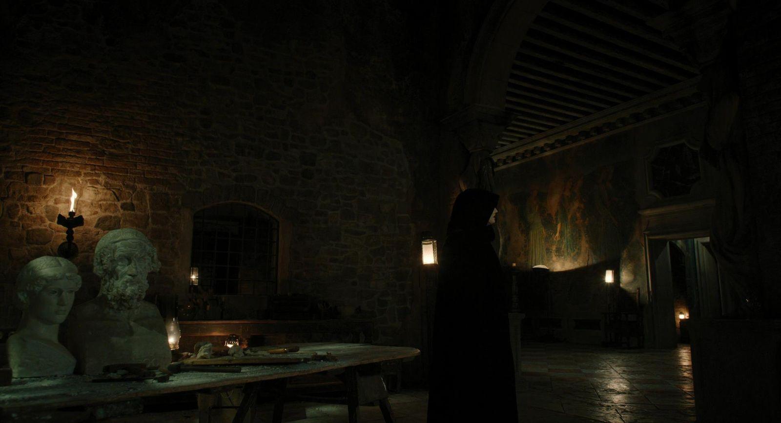 a person standing in a dark room next to a table