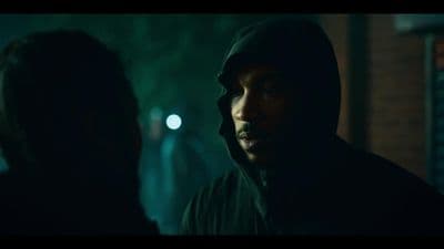 a man in a hoodie standing next to a woman