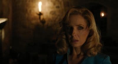 a woman standing in a dark room with a light on