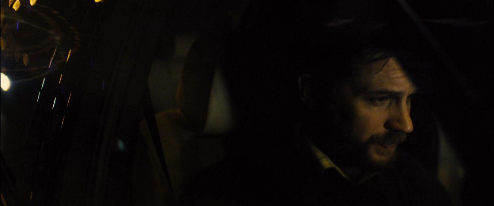 a man sitting in a car in the dark