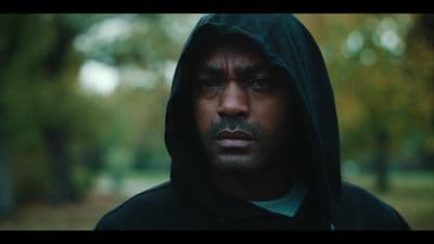 a man in a hoodie stares at the camera