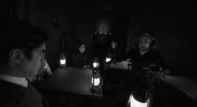 a group of people sitting at a table in a dark room