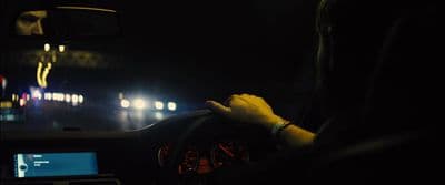 a man driving a car at night in the dark