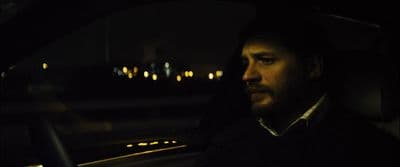 a man sitting in a car at night