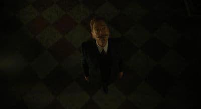 a man in a suit standing in a dark room