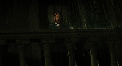 a man standing in front of a window in a dark room