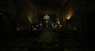 a dimly lit room with a chandelier hanging from the ceiling