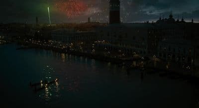 fireworks are lit up in the night sky over a river