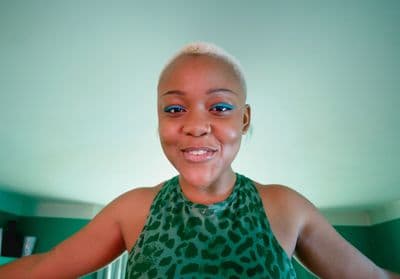 a woman in a green top is smiling for the camera