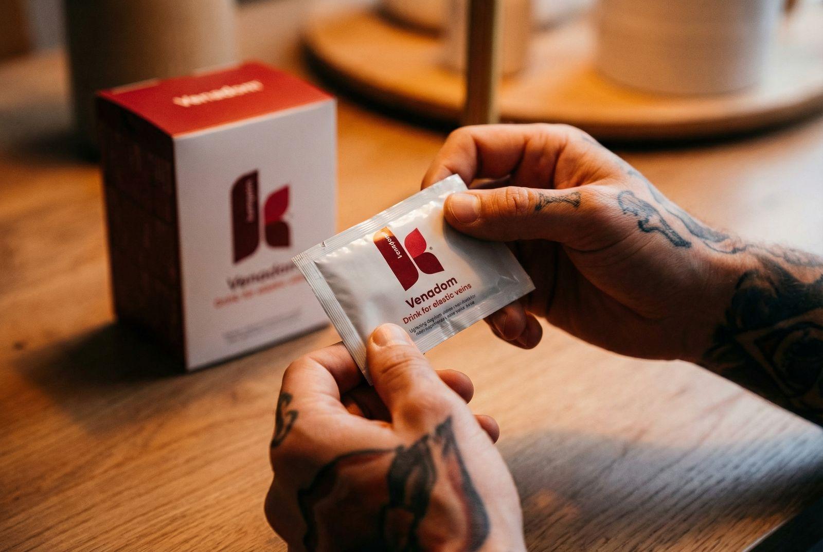 a man is holding a packet of kleenex