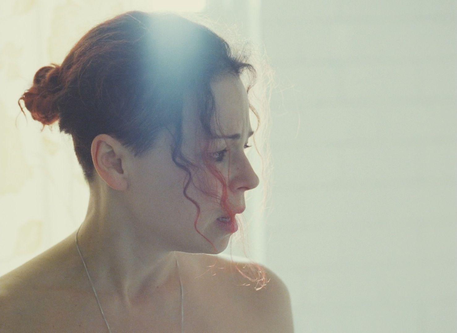 a woman with red hair is looking at herself in the mirror