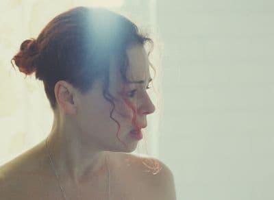 a woman with red hair is looking at herself in the mirror