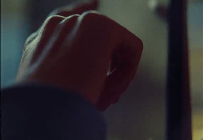 a person's hand reaching for something in a mirror