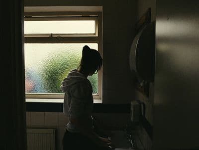a woman standing in a bathroom next to a window