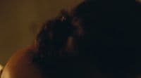 a blurry image of a woman's back with her hair in a bun
