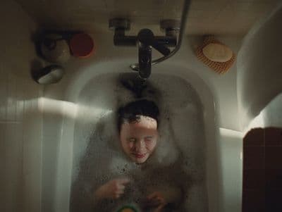 a woman in a bathtub with soap on her face