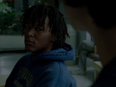 a man with dreadlocks looking at another man
