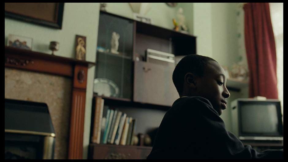 a man sitting in front of a tv in a living room