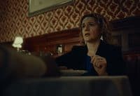 a woman sitting at a table in a restaurant