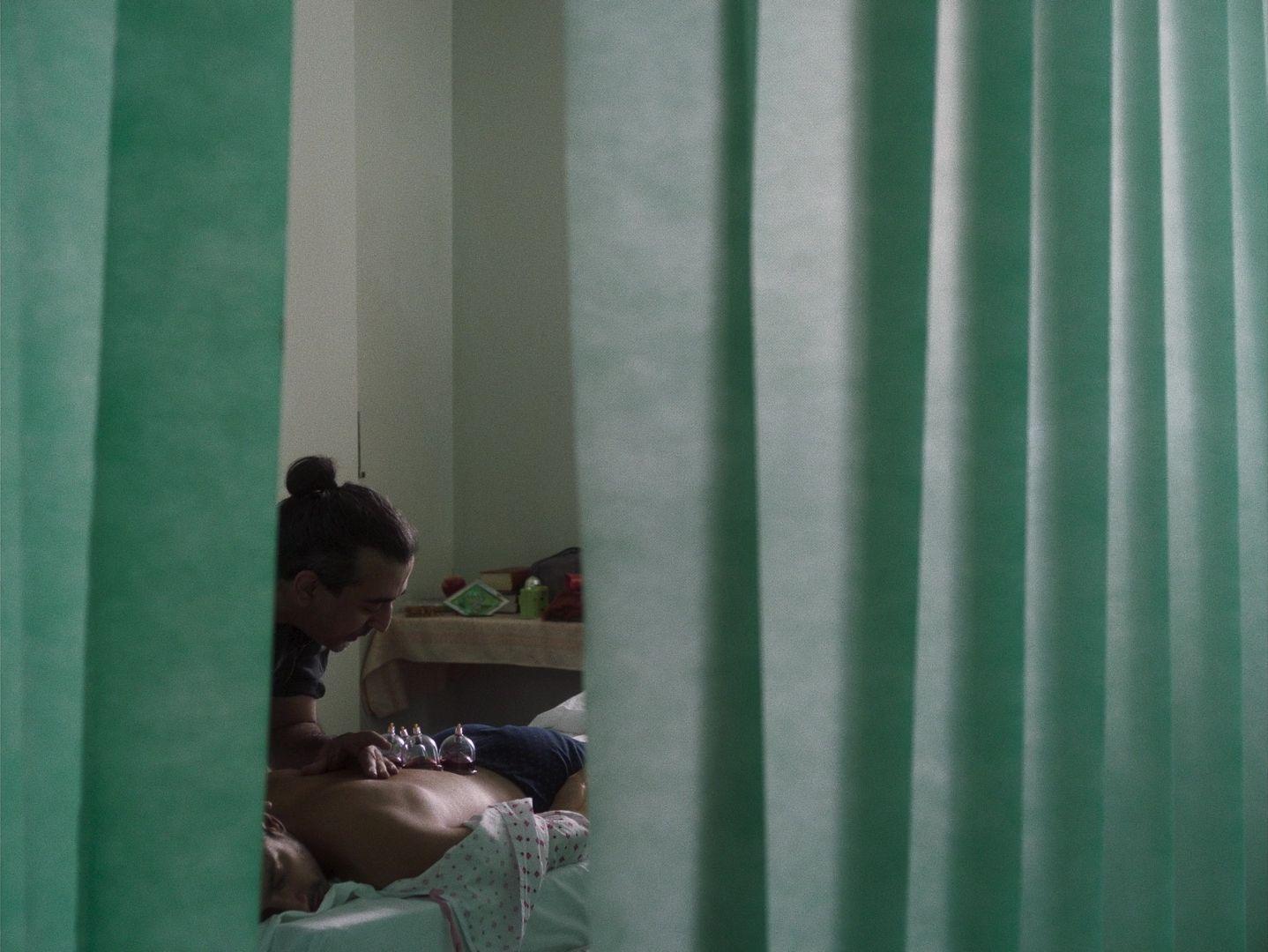 a woman sitting on a bed in front of a window