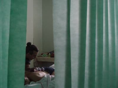 a woman sitting on a bed in front of a window