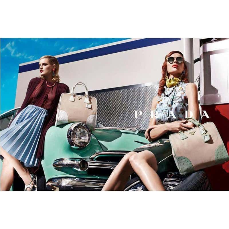 a couple of women sitting on top of a green car