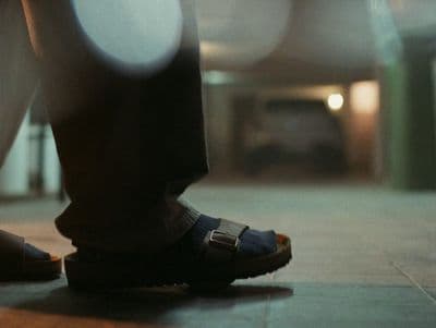 a person standing on a tiled floor wearing sandals