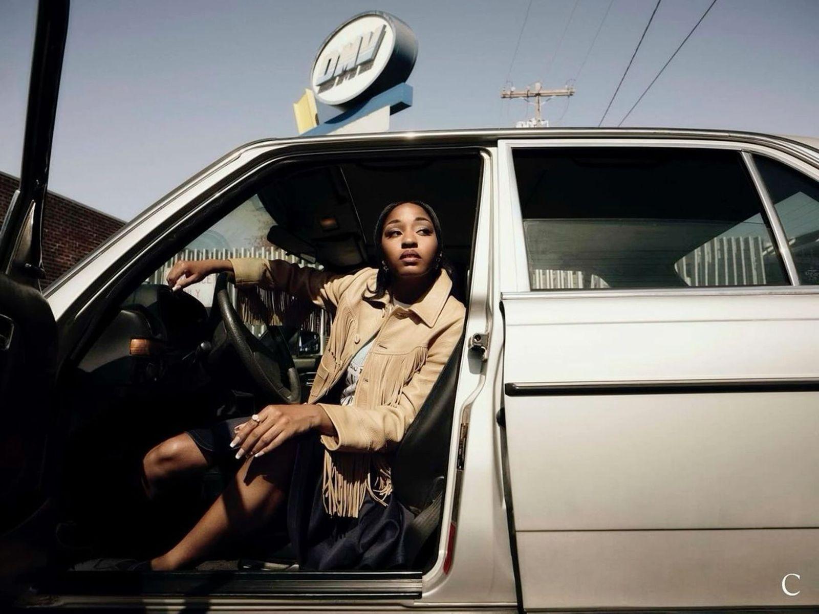 a woman sitting in the driver's seat of a car