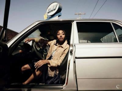 a woman sitting in the driver's seat of a car