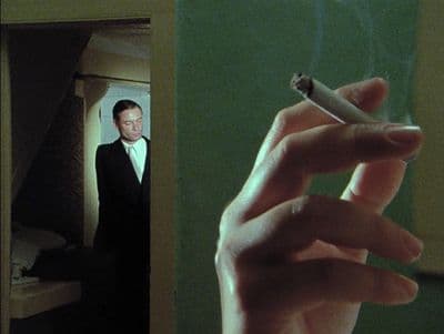 a man in a suit smoking a cigarette
