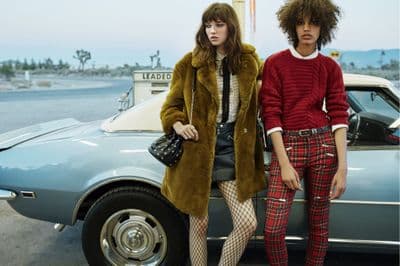 two women standing next to each other near a car