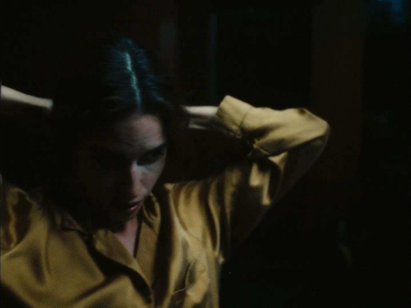 a woman in a yellow shirt is holding her head