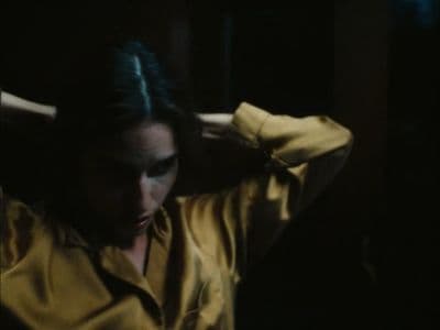 a woman in a yellow shirt is holding her head