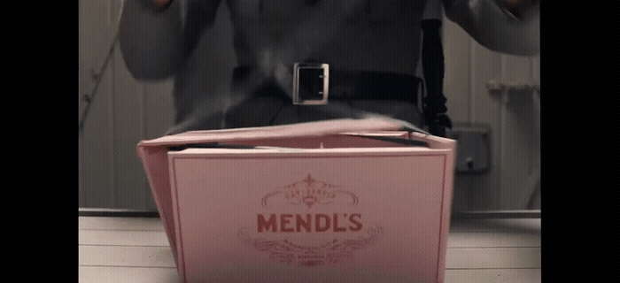 a man standing in front of a pink box
