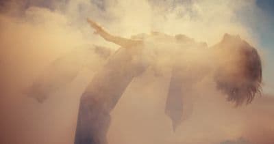 a woman standing in a cloud of smoke