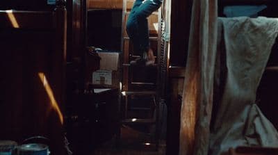 a person climbing up a ladder in a room