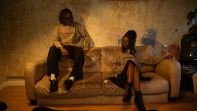 two people sitting on a couch in a living room