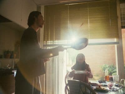 a man standing in a kitchen next to a woman