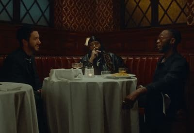 two men sitting at a table talking to each other