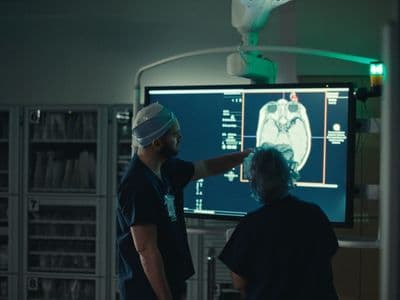 a man and a woman standing in front of a medical monitor
