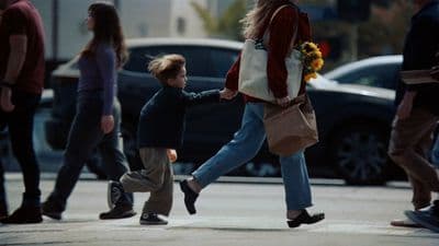 a woman walking down a street with a child